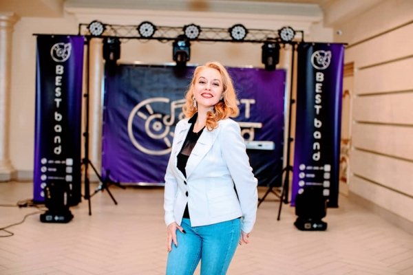 Співачка Вікторія радісно пишається своїм музичним колективом на фоні міні-сцени Best Band
