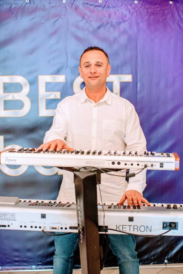 Радісний музикант Ярослав грає на своїх музичних електронних клавішах